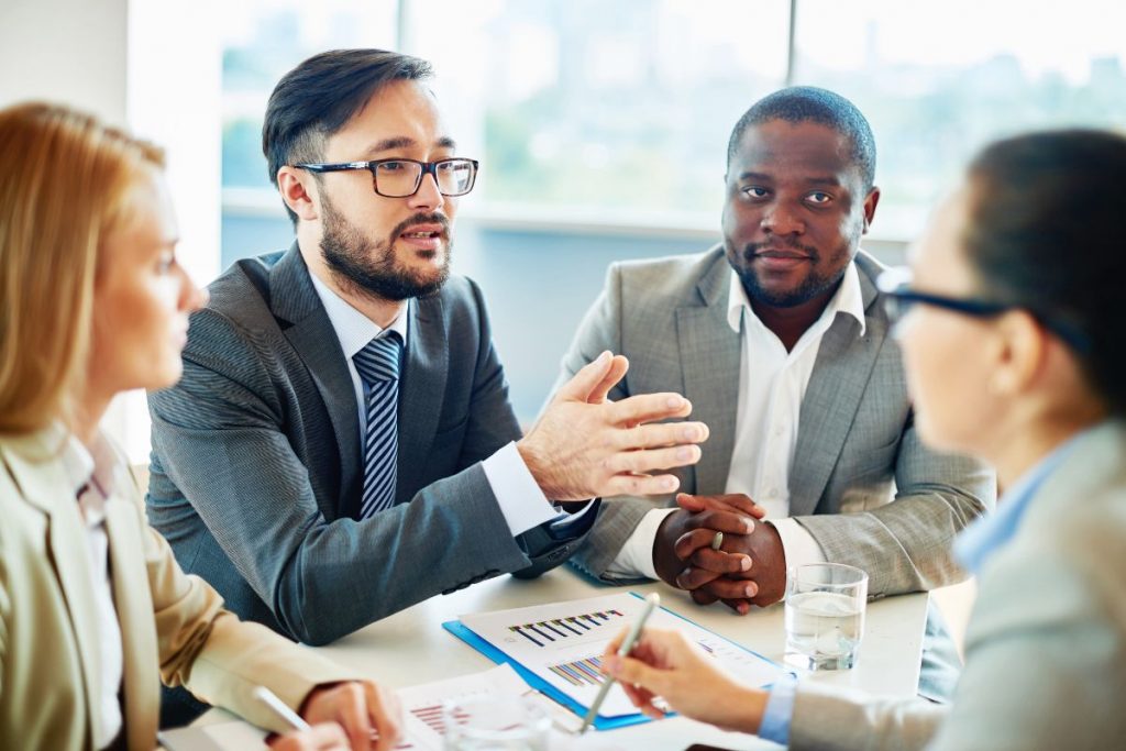 A group of business people talking at a meeting.