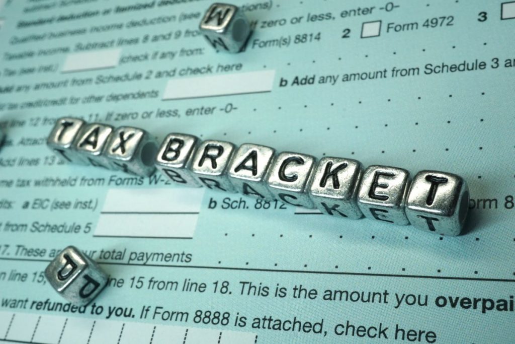 The word tax bracket is spelled out on a piece of paper.