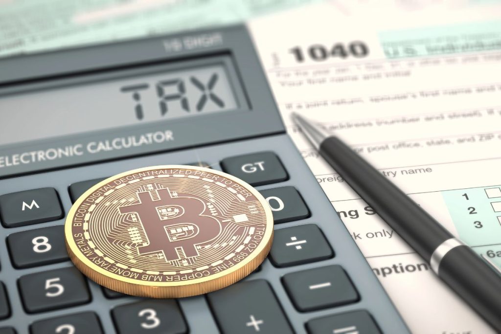 A Bitcoin token rests on a calculator displaying "TAX," highlighting the importance of IRS Crypto Cost-Basis Reporting Rules, next to a 1040 tax form and a pen.